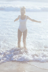 Fototapeta premium happy modern woman in white beachwear at beach having fun time