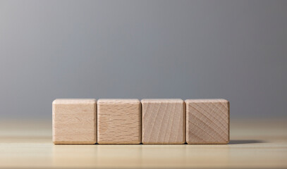 Four wooden blocks on wooden table with gray background
