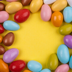 Almond candies, top view close up image of almond candies. Colorful, delicious, isolated on yellow background. Copy space text area. Square image. Traditional Turkish sugar feast greeting concept idea