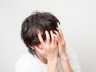Fototapeta premium 両手で顔を覆う男性