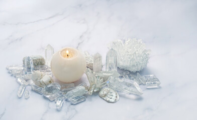 Quartz minerals and candle close up on abstract marble background. esoteric spiritual practice for aura cleansing, relax, life balance, soul relax, harmony. Crystal ritual, reiki therapy