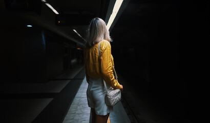 Woman is waiting for Subway train in the metro.