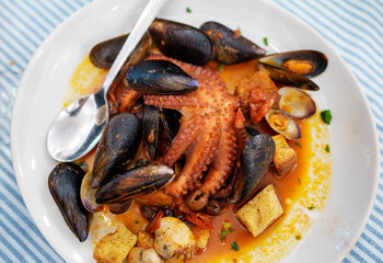 Stewed in tomato sauce Octopus with seafood and croutons.