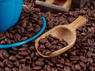 Antique vintage retro bronze coffee mill on black wooden board with roasted coffee beans     