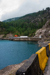 Fototapeta premium Beautiful and dangerous road, median and mountain by the lake