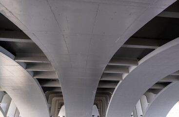 View of the arches of the concrete bridge from below.