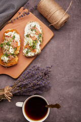 Table with sandwiches - smoked salmon, zucchini spread, coffee cup and bouquet of lavender. FODMAP, KETO, Mediterranean diet, Low carb, healthy superfood