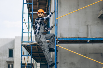 Foreman climbing ladder at building object