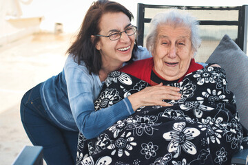 A middle-aged woman and a old woman having fun together and laughing