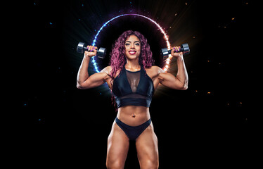 Modern muslim girl bodybuilder before bodybuilding competition. Fitness concept. Sport and health. Egyptian woman athlete with dumbbells posing on a black background.