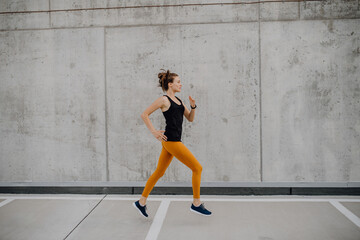 Young woman jogging in a city, healthy lifestyle and sport concept.