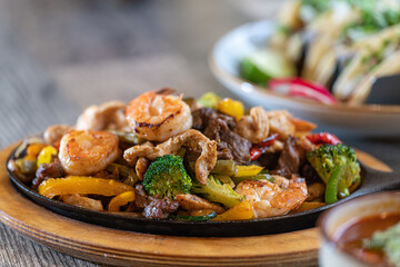 Seafood, beef and chicken fajitas on skillet