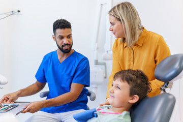 Liitle boy sitting on a dentists chair during dentist examination.