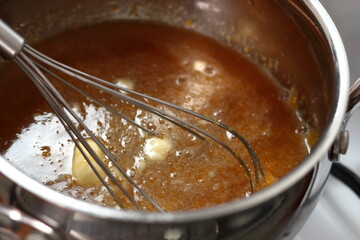 Saucepan with maple syrup, white wine, butter and egg. Simmer and whisk ingredients of pastry...