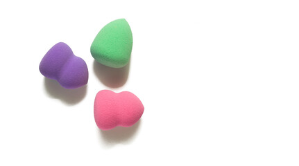 Colored makeup sponges purple, pink, green on a white background. Means for applying professional make-up