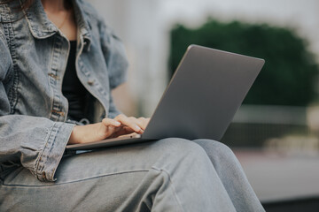 Close up of young woman using laptop outdoors