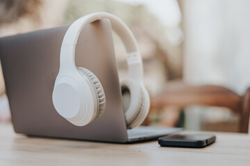Modern wireless headphones and laptop computer while resting. Set up a workspace or home office to...