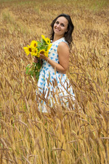Happy Young Woman with Bouquet of Sunflowers in the Wheat Field 