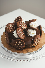 Delicious homemade dark chocolate cake with chocolate cookies and cream on top