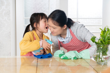 The little girl and her mother are cleaning at home together