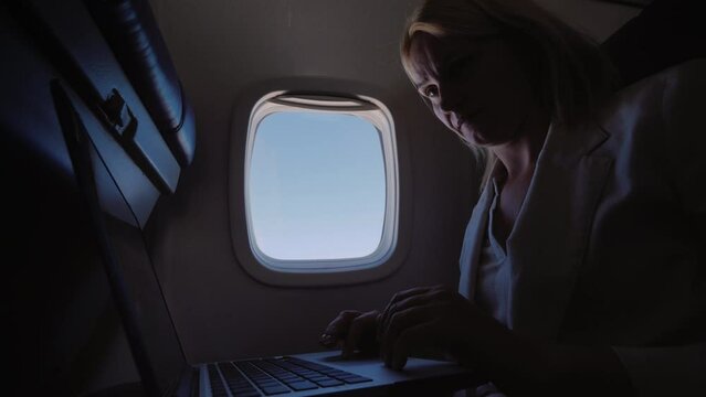 Business woman using laptop in flight