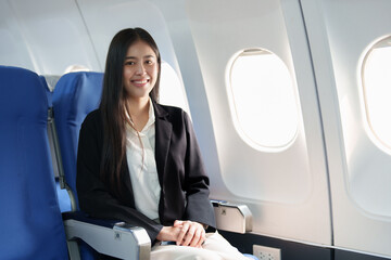 Asian business woman passenger sitting on business class luxury plane while working using smart phone mobile talking or video conference and travel concept