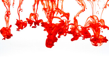 Red paint dissolving in water creating abstract shapes 