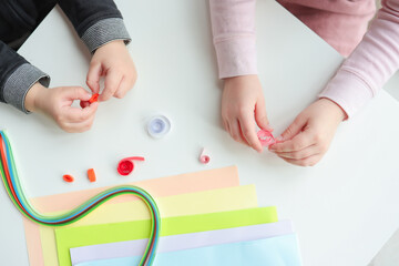 Children's activities, hands with paper top view, quilling technology