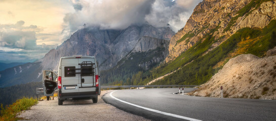 Vacation and travel Concept Beautiful mountain summer landscape with a road and a car on the roadside at sunset. Traveling by auto