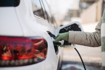 Close up of urecognizable person charging electric car.