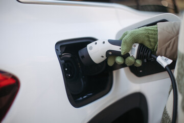 Obraz na płótnie Canvas Close up of urecognizable person charging electric car.