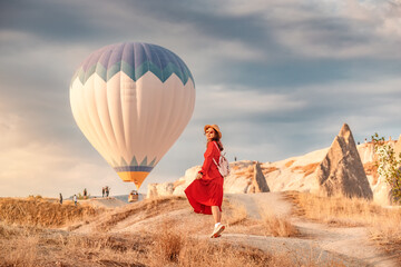 Girl stood amidst the orange rocks of Cappadocia watching dreamily as the balloons floated away...