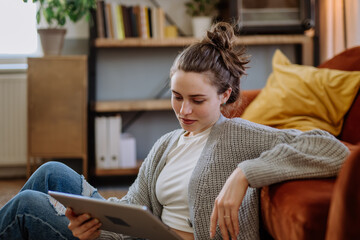 Young woman with digital tablet resting in her apartment.