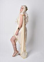Full length portrait of beautiful blonde woman wearing a fantasy goddess toga costume with  magical...