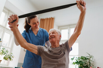 Young nurse doing exercise with senior man.