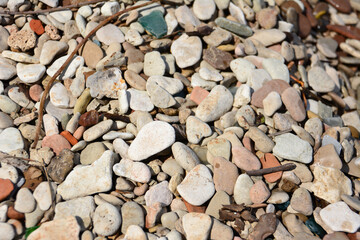 A pile of multicolored pebbles isolated on the beach, close-up   