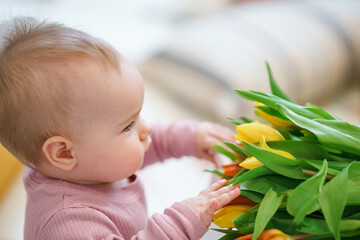 Cute little girl toddler with a bouquet of tulips