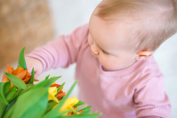 Cute little girl toddler with a bouquet of tulips