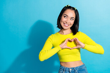 Photo of young charming attractive cute japanese lady fingers demonstrate sympathy heart symbol look mockup dream isolated on blue color background