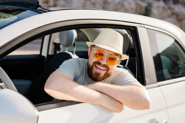 Happy man sitting in white convertible car with beautiful view and having fun - travel summer...