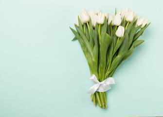 White tulip bouquet on color background, top view