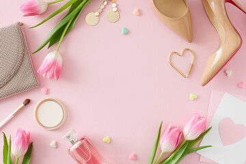 Flat lay photo of trendy woman shoes makeup powder and brush perfume bottle handbag postcard with heart and pink tulips on pastel pink background with empty space in the middle. Mother's Day concept