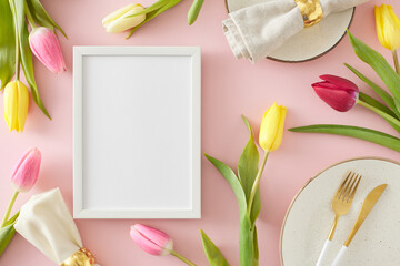Table setting concept. Top view photo of white photo frame circle plates cutlery knife fork fabric napkin with gold ring and colorful tulips on isolated pastel pink background