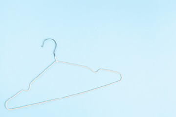 Creative flat lay hanger pastel blue background. Sale discount store promo shopping concept. Top view. Copy space