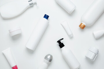 Cosmetic beauty products on white background. Bottles and tubes with branding mock up. Skin care and beauty concept. Top view, flat lay, copy space