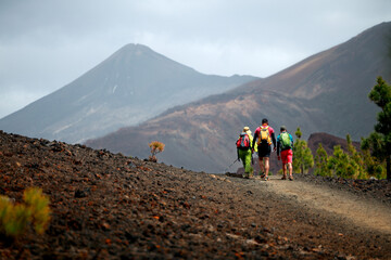  Group of friends hiking in Tenerife with a volcano in the background. Scenic hike landscape