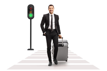 Full length portrait of a businessman with a suitcase crossing street at a pedestrian - obrazy, fototapety, plakaty