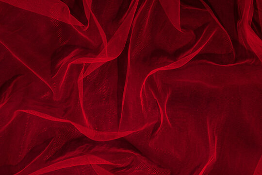 Dark elegant wallpaper made of red tulle fabric. Aesthetic fashion, passion and love background.