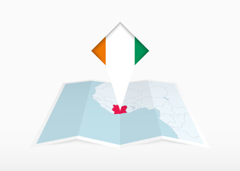 Ivory Coast is depicted on a folded paper map and pinned location marker with flag of Ivory Coast.