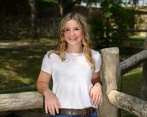 Young pretty teenage girl posing in a historic setting for her high school graduation photos